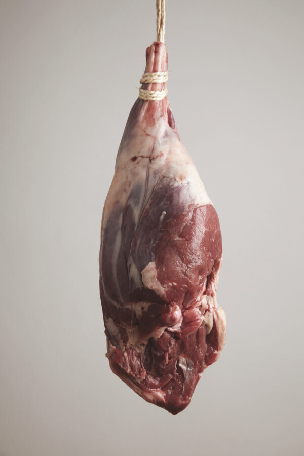 lamb leg raw mead on rope for smoking process